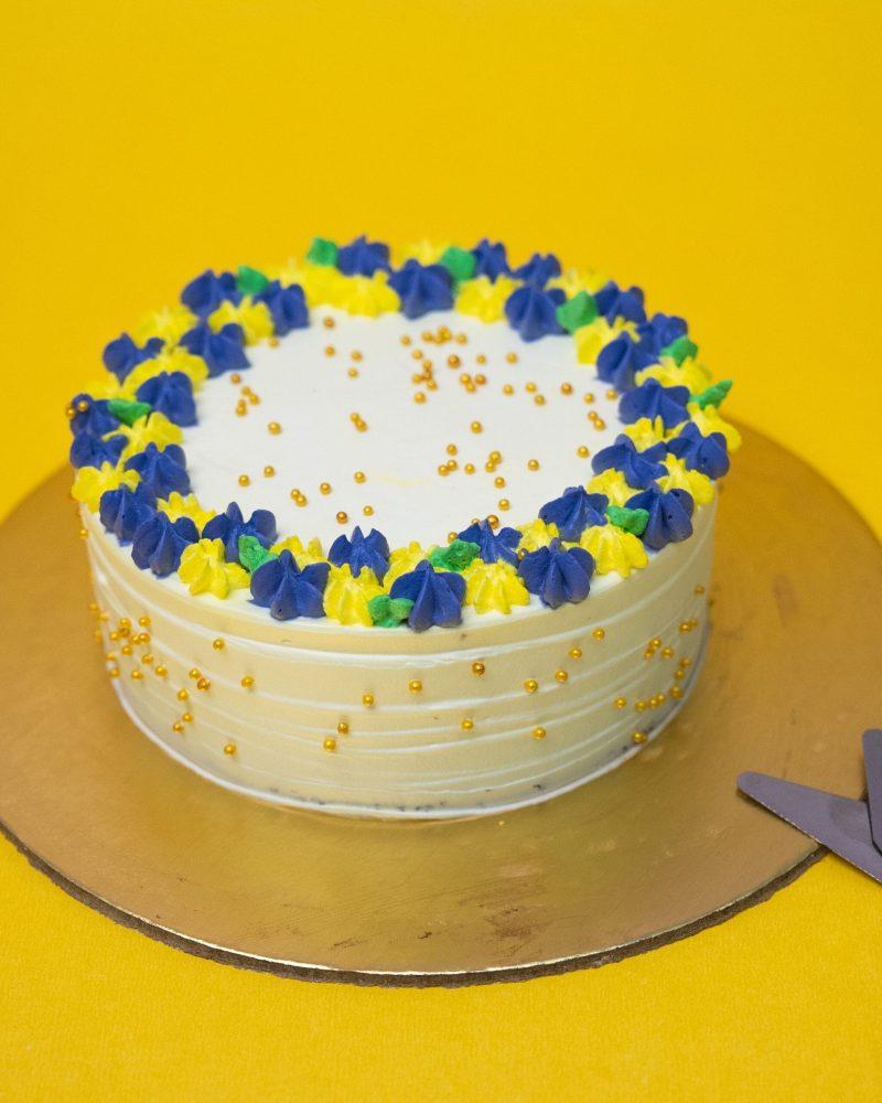 White Cream Cake Decorated Buttercream Flowers with golden pearls