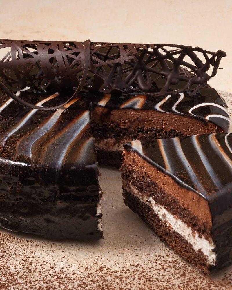 sweet sponge chocolate cake on a plate decorated with cocoa powder